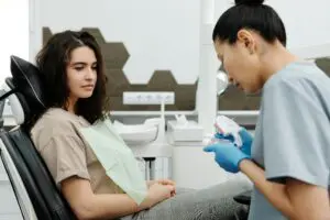 Photo by Cedric Fauntleroy: https://www.pexels.com/photo/dentist-with-patient-4269369/ A periodontist and a female patient discussing all-on-4 procedure steps