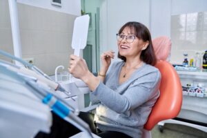 Woman admiring smile in dentist's office